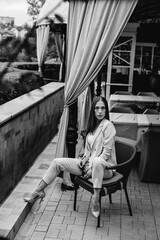 Obraz premium Sexy girl sitting on a beautiful veranda. Black and white.