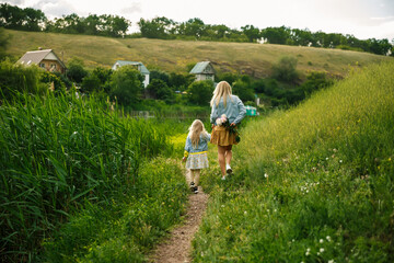 Mother and daughter walking near the river. Family concept