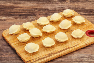 Raw dumplings over board for cooking