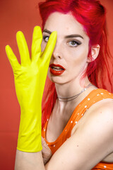 Girl on a pink background in yellow gloves