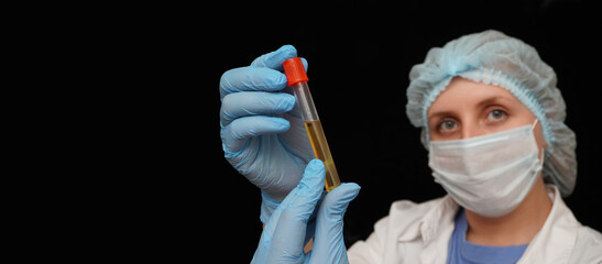 Female doctor in medical protective mask and gloves holding a 
test tube with the covid-19 vaccine.  Healthcare And Medical concept.
