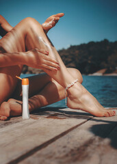 Sun protection on woman skin in summer.Sunbath concept. Suncream on leg - 355280871