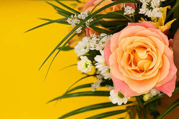 Bright colorful bouquet with an orange rose on a yellow vertical background.