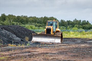 Bulldozer dredges rubble on road construction