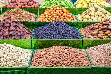 Dried fruits and nuts for sale on a market counter.