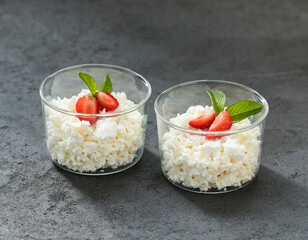 Cottage cheese with strawberries in a glass Cup on a dark gray background