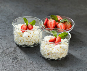 Cottage cheese with strawberries in a glass Cup on a dark background