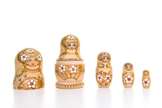 Set of five wooden matryoshka dolls standing in a row, from large to small isolated on a white background