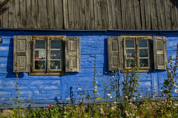 Blue wooden outer wall of a country house with two windows