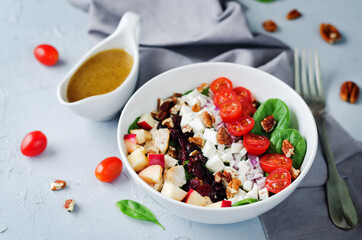 Chicken spinach apple tomato goat cheese salad in a bowl