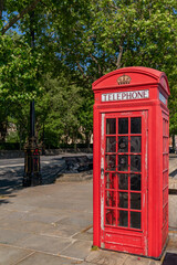 Traditional red London public telephone box on the embankment in London, England