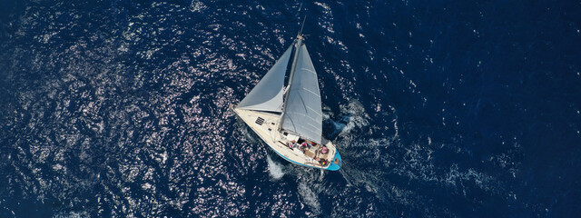Aerial drone ultra wide photo of beautiful sail boat with white sails  sailing open ocean deep blue...