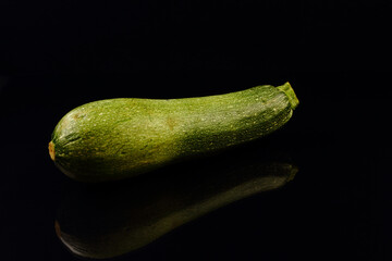 Fresh green zucchini isolated over black background.