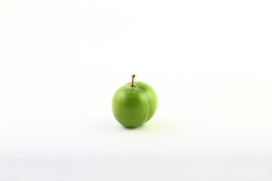 Single whole fresh green Can Erik plum close up isolated on white background.   green plums pictures from the first fruits in summer