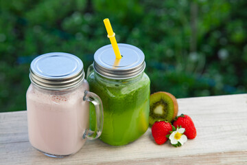 Detox smoothie and fruit on wooden table in the garden with fruit.