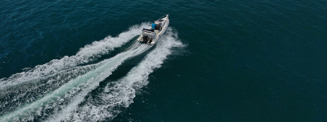 Aerial drone ultra wide photo of inflatable powerboat cruising in high speed near Mediterranean port