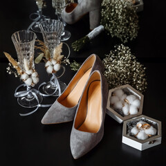 Wedding glasses, shoes and a box with wedding rings on a black background. Wedding accessories