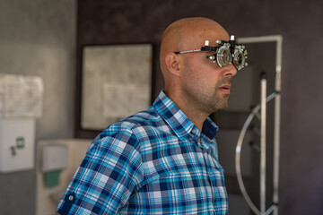 vision measurement by optometrist at clinic, young man as patient