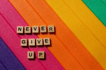 Words written on wooden blocks. Colorful background. Never give up. Motivational message. Words and phrases. Never give up writing. Positive background. Colors