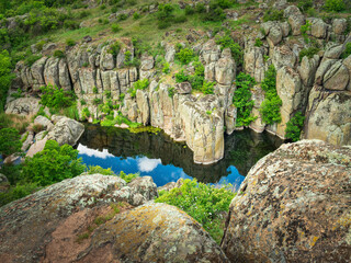 top view to rocks and water with sky reflection in it in canyon in Ukraine