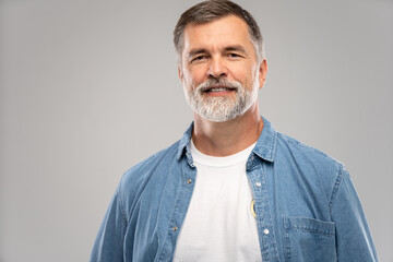 Portrait of smiling mature man standing on white background.