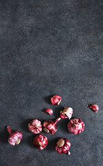 Fresh red garlic on a black, concrete background. View from above.