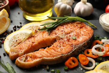 Composition with tasty grilled salmon on black background, close up