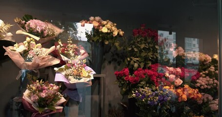 Flower delivery. Close up beautiful fresh blossoming flowers in the florist shop. Flower shop concept. Different varieties fresh spring flowers in refrigerator room for flowers. 4k