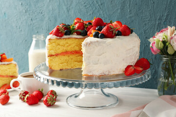 Composition with delicious berry cream cake on white wooden table. Tasty dessert
