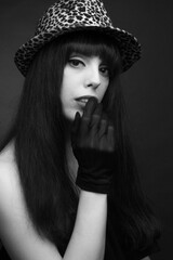 Black-and-white portrait of a young woman in a hat and gloves
