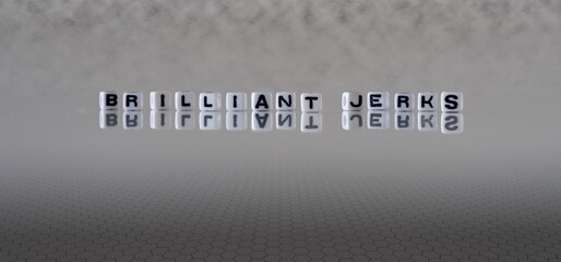 brilliant jerks concept represented by black and white letter cubes on a grey horizon background...