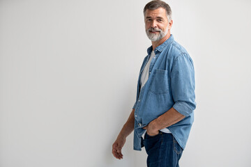 Portrait of smiling mature man standing on white background.