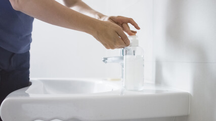Female using hand sanitizer gel pump dispenser for bacteria and virus disinfection.