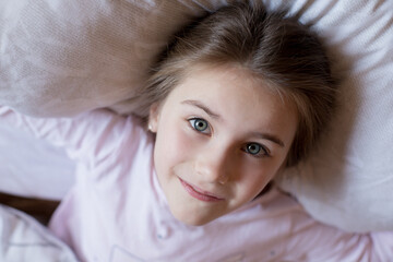 Cute little girl in bed woke up in the morning