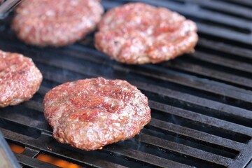 Several minced steaks on the gas grill