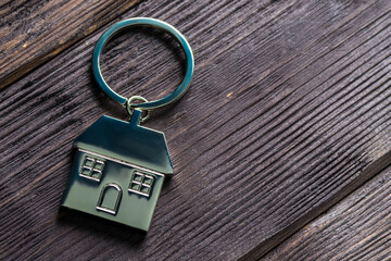 close-up keychain in the shape of a house on wooden boards