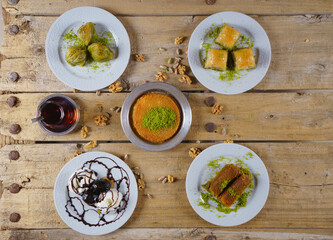 Turkish Dessert kunefe, kadayif and baklava with pistachio powder on rustic wood table