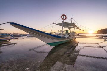 Trip long banca boat on Corong corong beach, sunset flare shine. El Nido, Philippines