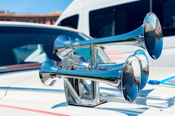 A close-up view of a chrome horn on the hood of a car