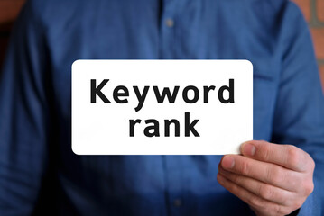 Keywords rank - text on a white sign in the hand of a man in a blue shirt