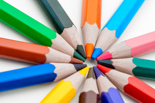 circular layout of colored pencils on a white background is isolated