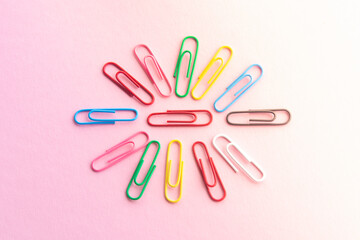 multicolor paper clips , stationery for school or business on a purple background
