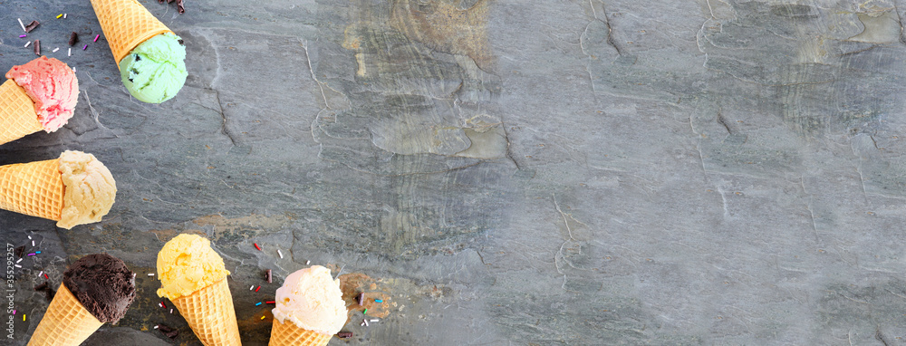 Poster ice cream cone corner border with a variety of flavors. above view over a dark slate banner backgrou