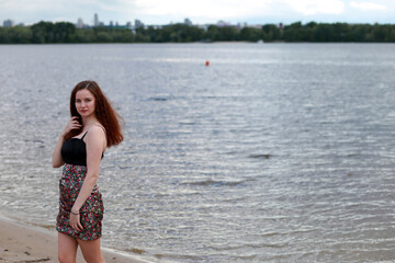 Fototapeta na wymiar A girl at the river shore in spring