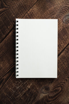 Top view image of an open notebook with blank pages on a wooden table. Ready to add text or layout. Space for text or image.