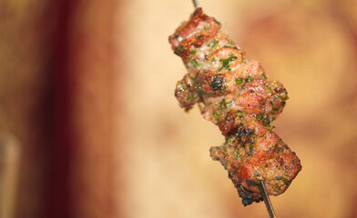 Grilled kebab cooking on metal skewer.