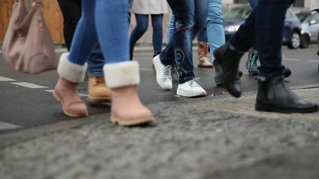 Lots of Peoplees walking on the sidewalk. CLose Up