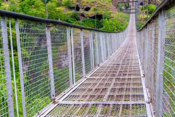 Metal mesh suspension bridge over the gorge - a landmark of Armenia in Khndzoresk