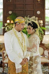 Traditional java wedding couple bride and groom hold each other with smilling face.