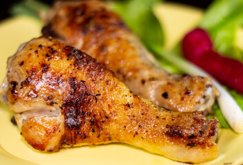 Appetizing fried chicken legs on plate with herbs